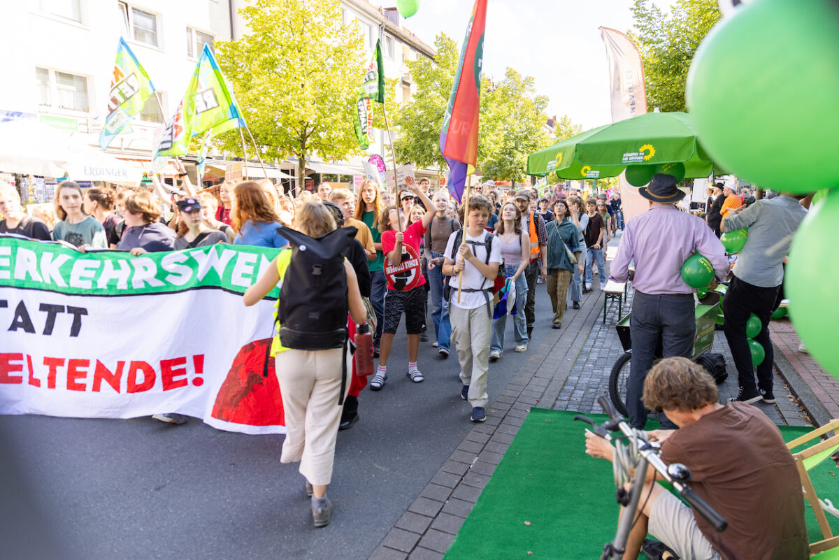 Demonstrierende von der Klimademo vor dem Grünen Stand