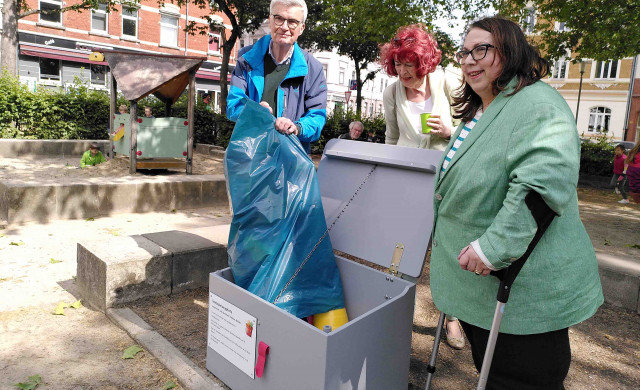 Grünen-Mitglied Uli Zorn befüllt die Spielzeugkiste, für die er sich stark eingesetzt hat. Bezirksbürgermeisterin Antje Kellner (rechts) und CDU-Bezirksratsfrau Ellen Maschke-Scheffler schauen zu. (Foto: Hoff)