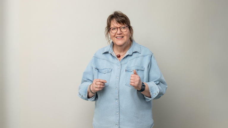 Claudia Bax freundlich sprechend in einem blauen Jeanshemd