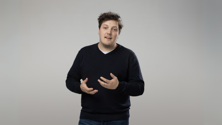 Das Bild zeigt Liam Harrold in einer Körperhaltung als Sprechender