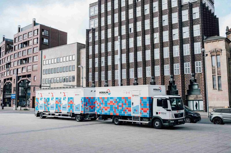 Das Bild zeigt einen umgebauten LKW, der mehrere Duschkabinen enthält. Der LKW steht auf dem Goseriedeplatz in Hannover.