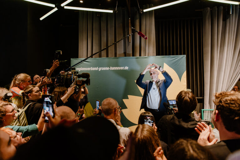 Belit formt mit den Händen ein Herz auf der Wahlparty
